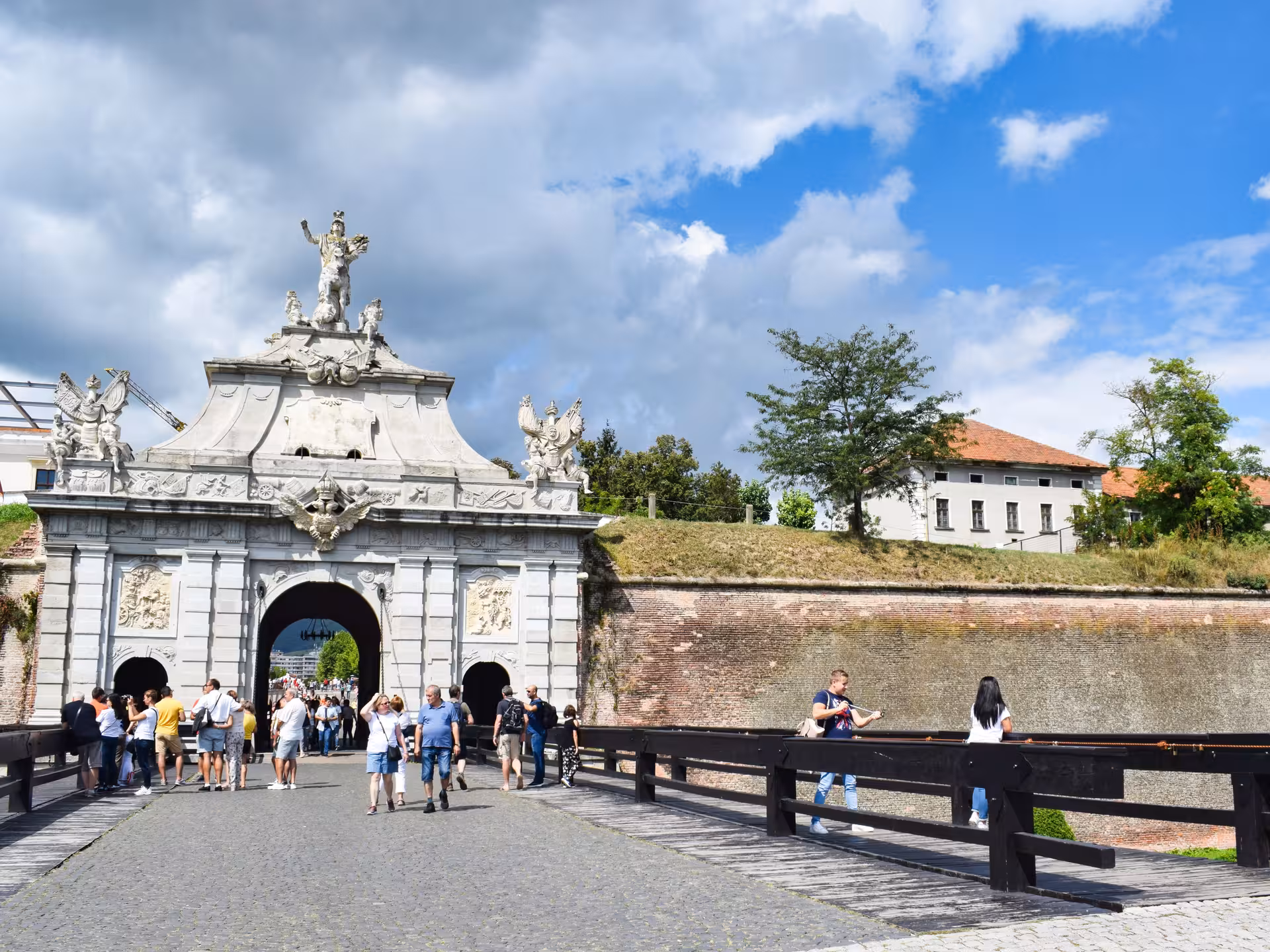 Visitors exploring the ornate Baroque gate of Alba Carolina Fortress on a Transylvania castle tour