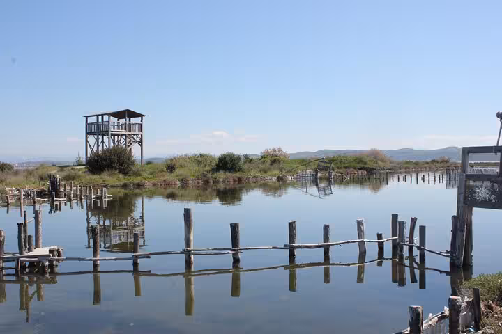 Scenic view of a wooden lookout tower by a serene lake in Albania, perfect for nature exploration on a 6-day tour.