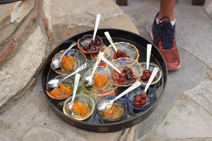 Traditional Albanian desserts displayed in glass bowls during a day trip to Berat, showcasing local culinary delights.