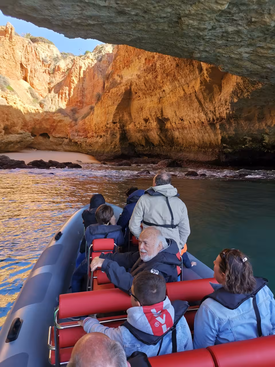 Albufeira RIB boat inside Algarve sea cave near Benagil, guests sightseeing on coastal caves and dolphins cruise