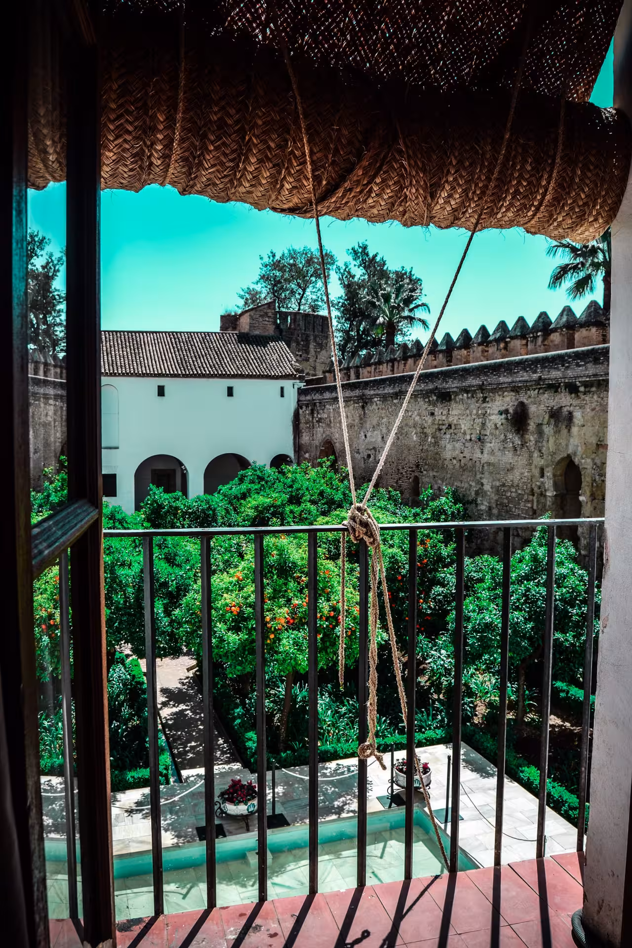 View from a balcony overlooking the lush gardens of the Alcázar of the Christian Monarchs in Córdoba, Spain.