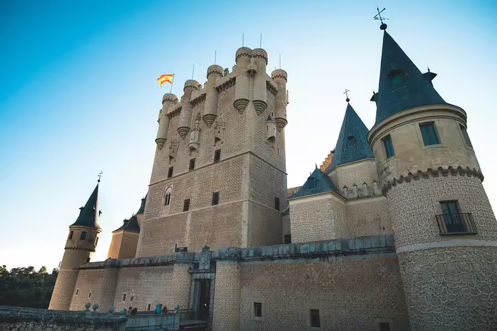 Alcazar of Segovia castle exterior at sunset, iconic landmark on private minivan tour to El Escorial and Segovia