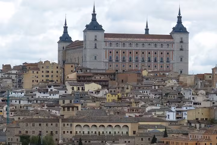 Alcázar of Toledo surrounded by historic buildings, showcasing the rich architectural heritage of the city.