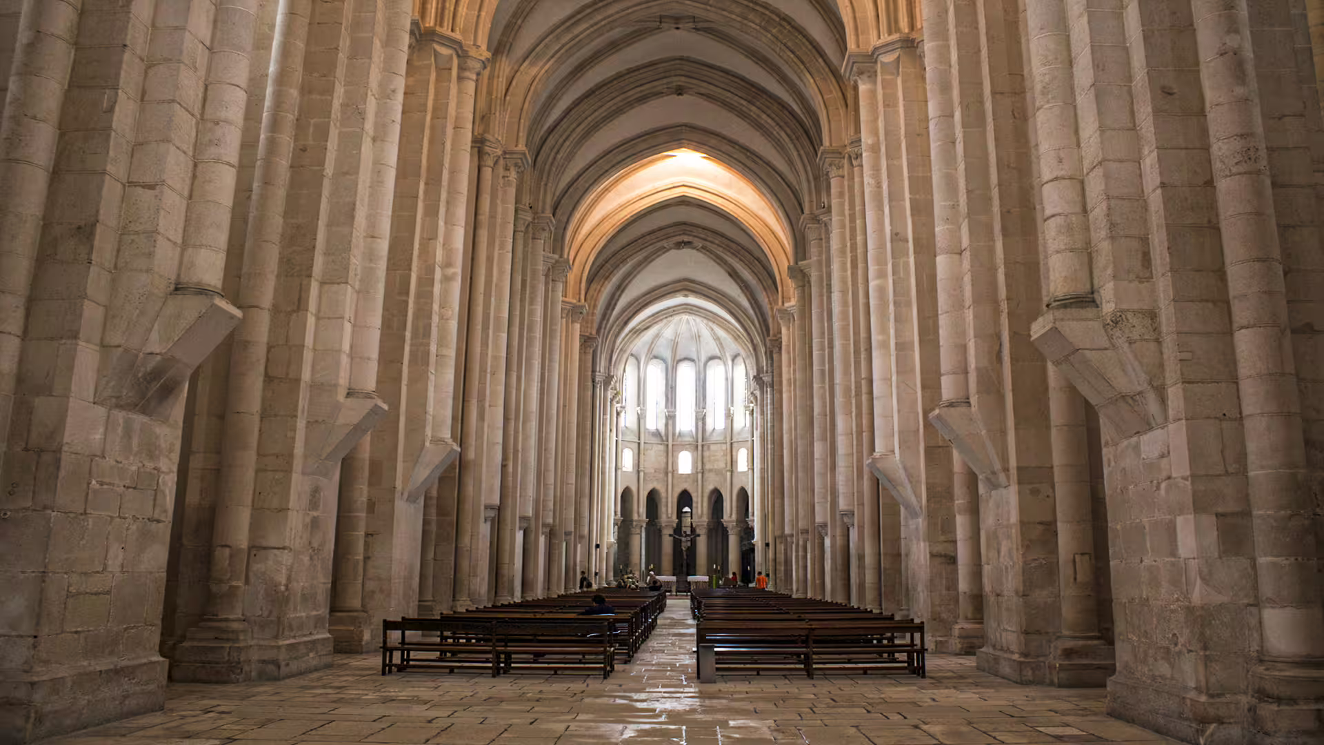 Interior of Alcobaça Monastery showcasing its impressive Gothic arches and serene ambiance on a private Nazaré tour.