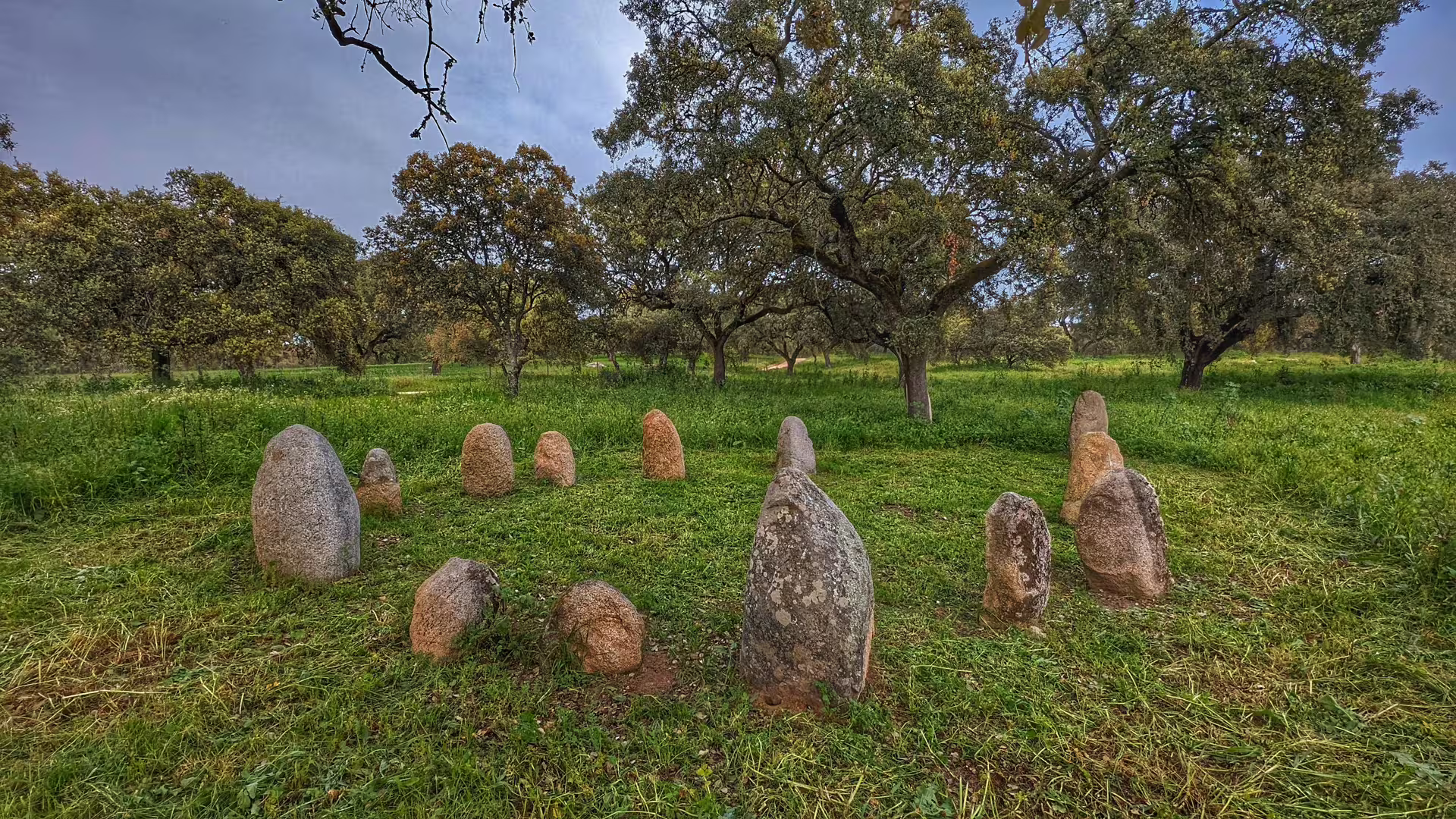 Ancient stone circle set amidst a verdant Alentejo forest landscape.