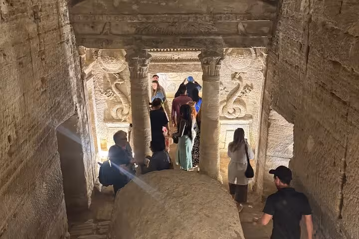 Visitors descend into Alexandria catacombs tomb corridor on a private VIP day tour with local guide and lunch