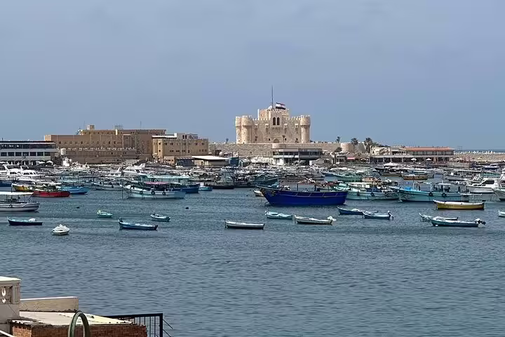 Alexandria harbor boats with Qaitbay Citadel in background, scenic day trip on 6-day Egypt tour package