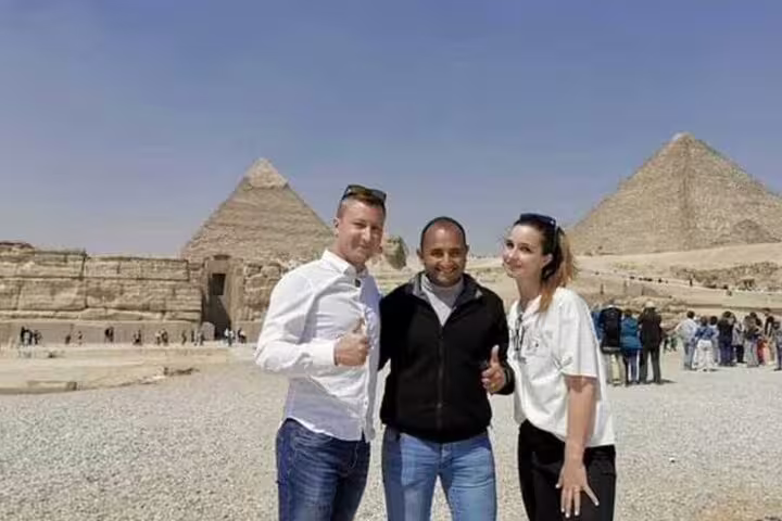 Private Alexandria Port day trip guests with guide at Giza Pyramids, Cairo shore excursion photo stop