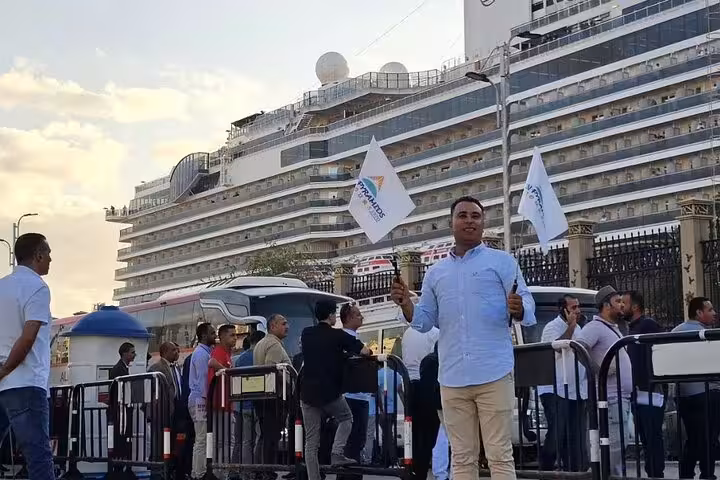 Tour guide greets cruise passengers at Alexandria Port pickup for Pyramids and Grand Egyptian Museum day trip