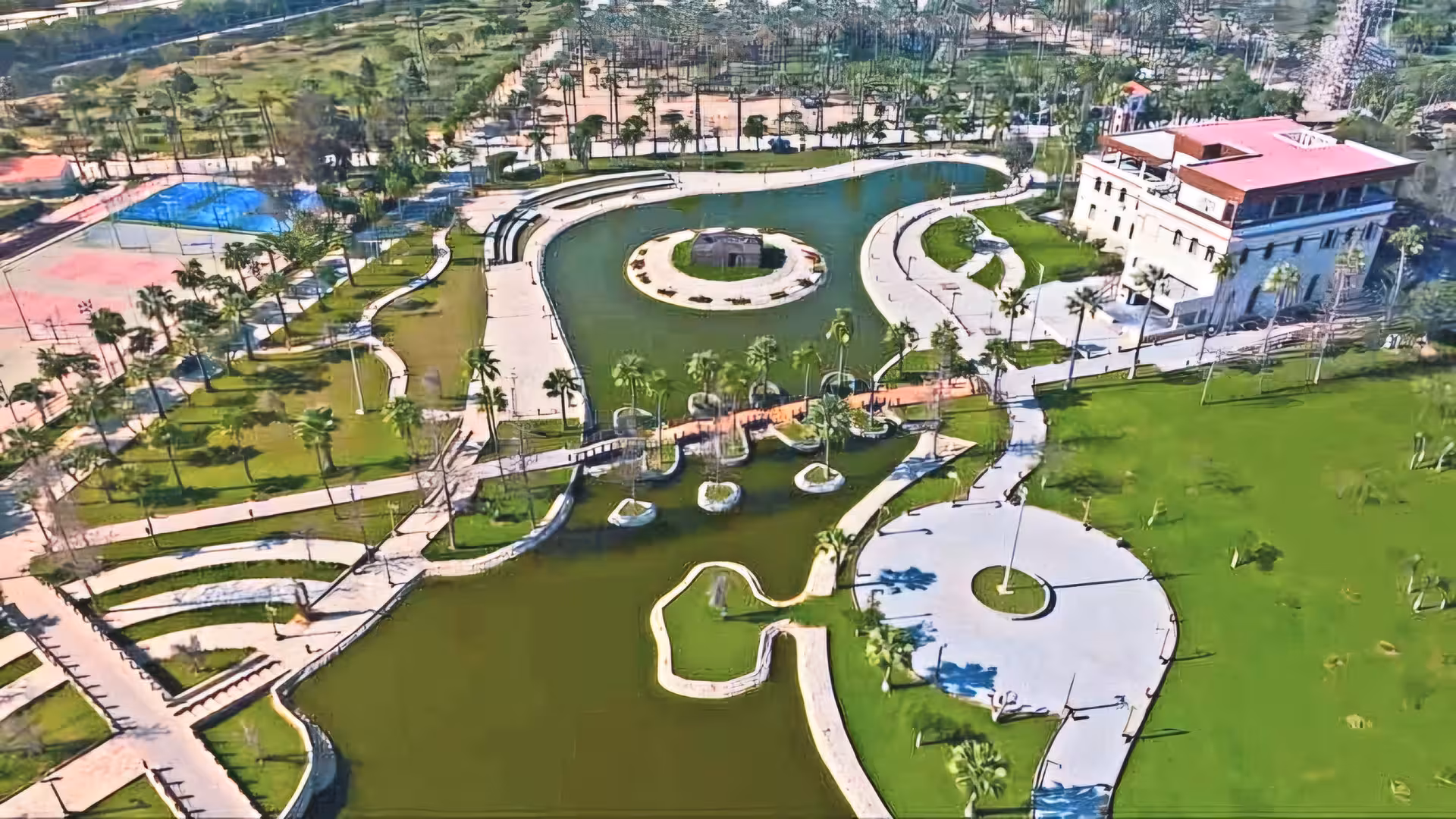 Aerial view of Alexandria Royal Gardens with winding waterways, palm trees, and historic white building