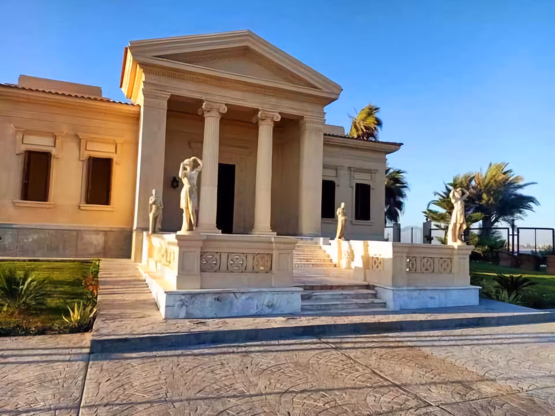 Neoclassical building with Ionic columns and classical statues at Alexandria Royal Gardens