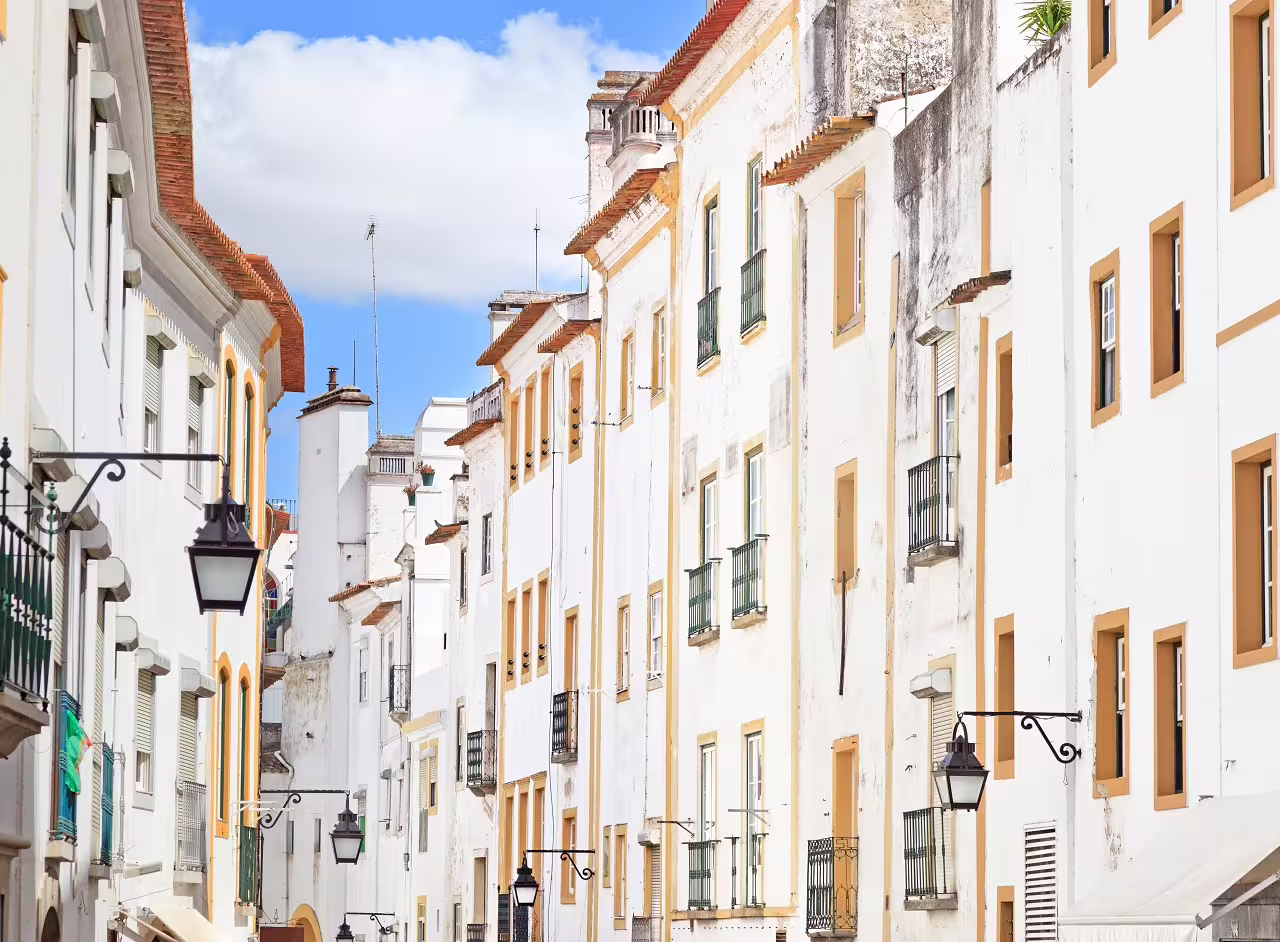 Charming street view of traditional whitewashed buildings in the Algarve and Alentejo, perfect for a self-drive tour exploration.