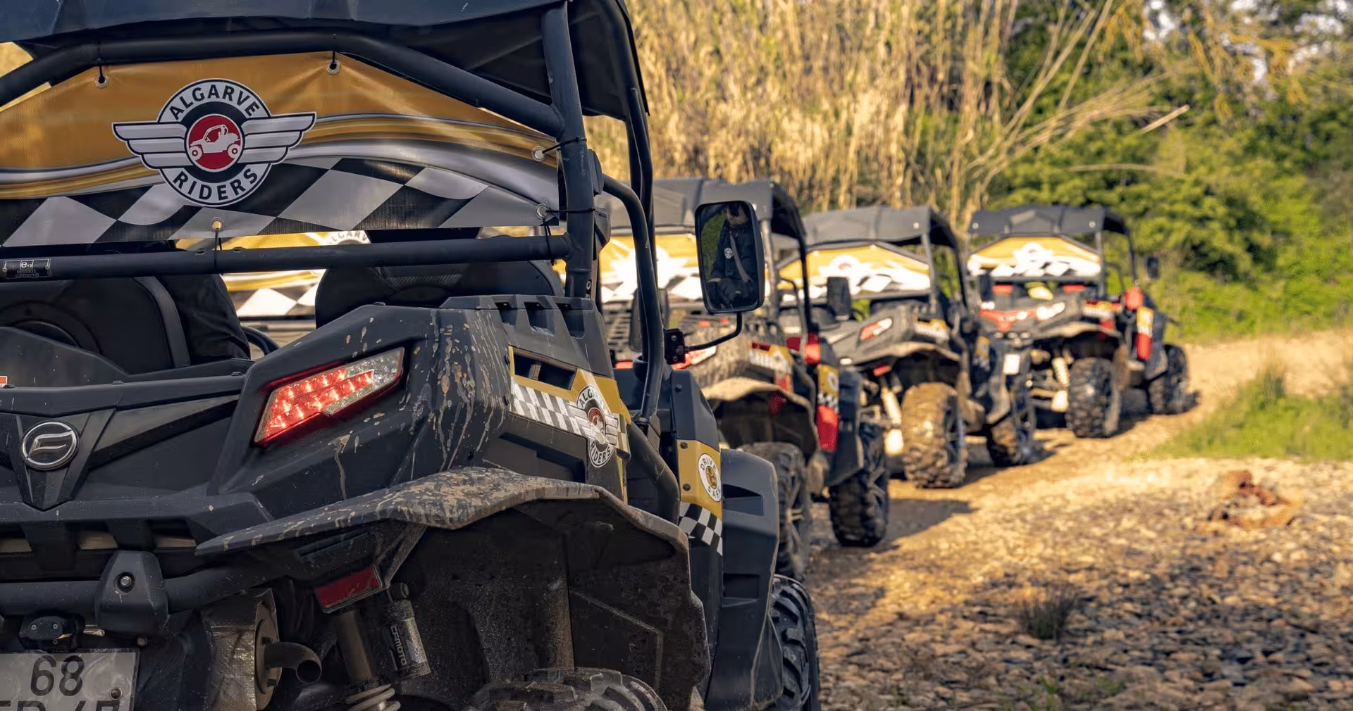 Line of muddy Algarve Riders buggies parked on a rugged dirt trail during a guided full day off-road buggy tour