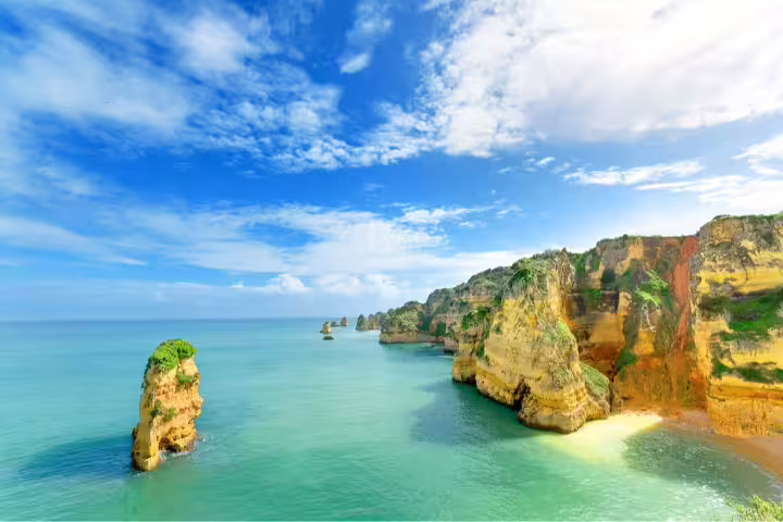 Stunning Algarve coastline view with dramatic cliffs and turquoise waters, perfect for a South of Portugal tour from Lisbon.