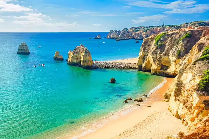 Stunning Algarve coastline with turquoise waters and rocky cliffs, a highlight of the Algarve to Porto scenic tour.
