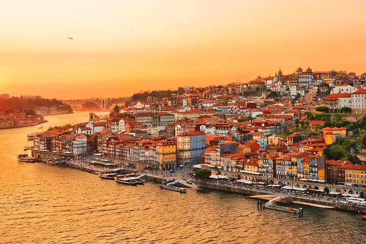 Scenic sunset over Porto's vibrant riverside, showcasing the city's charm on the Algarve to Porto travel route.