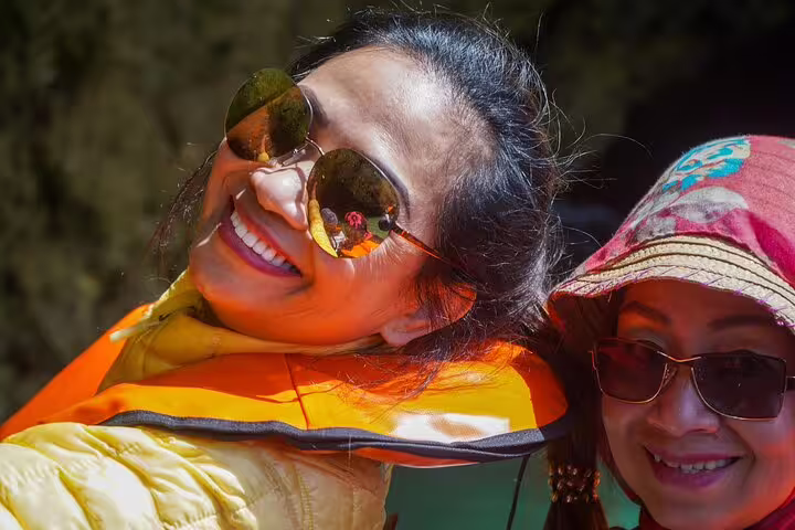 Happy tourists enjoying a sunny Algarve private tour from Lisbon, featuring a boat trip to the stunning Benagil Caves.