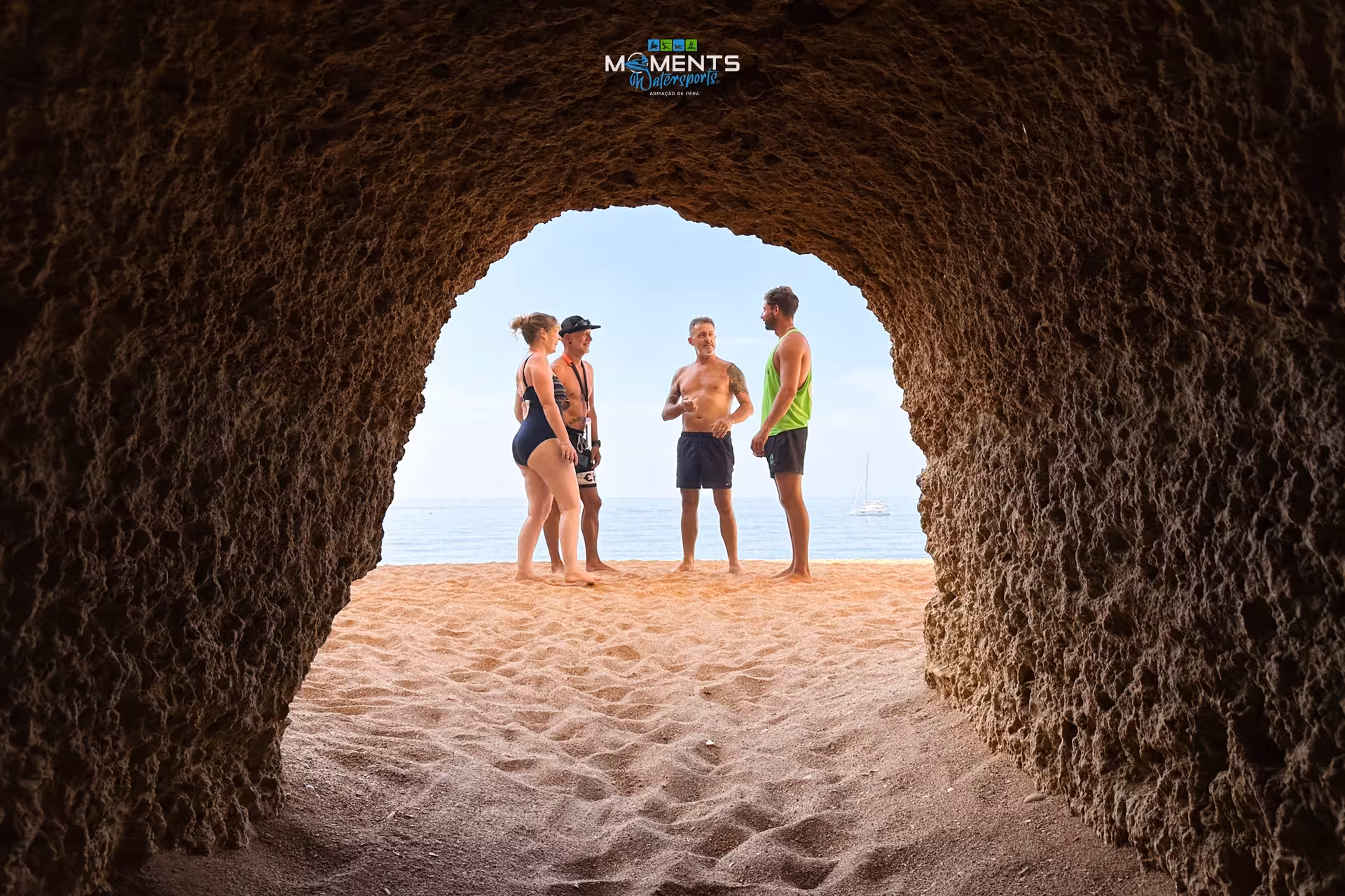 Tour group exploring a stunning Algarve sea cave entrance on a guided kayak adventure along the coastline