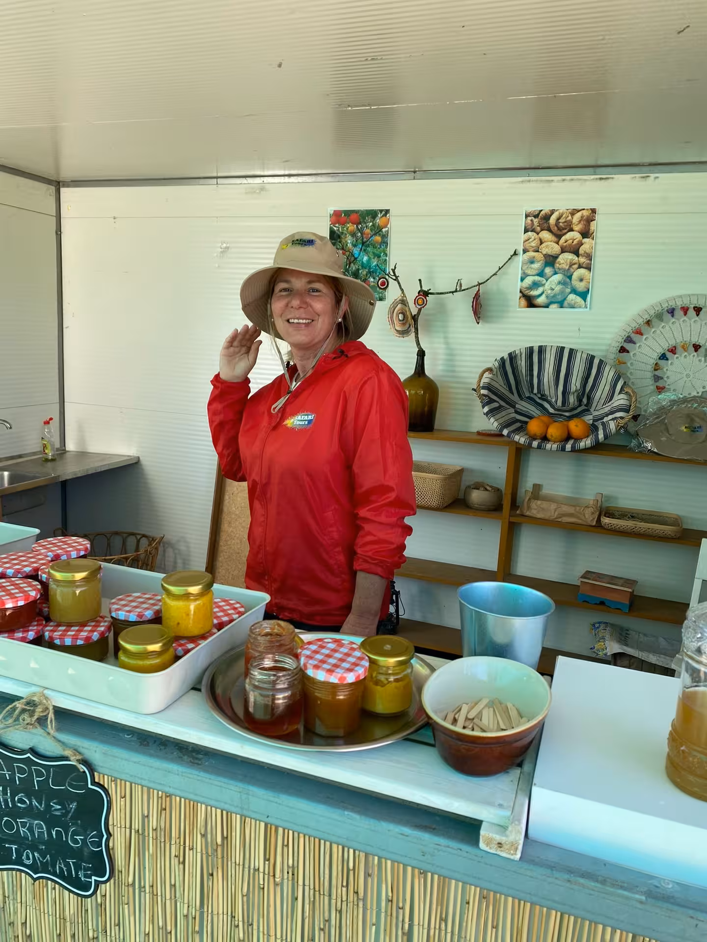 Local Algarve guide in red jacket serving homemade honey and jams at rustic farm stop on sunset Jeep safari tour