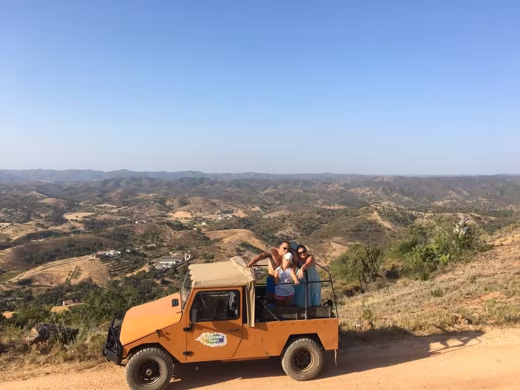 Friends enjoy a scenic Algarve hilltop jeep safari at sunset, sipping sparkling wine and admiring panoramic views