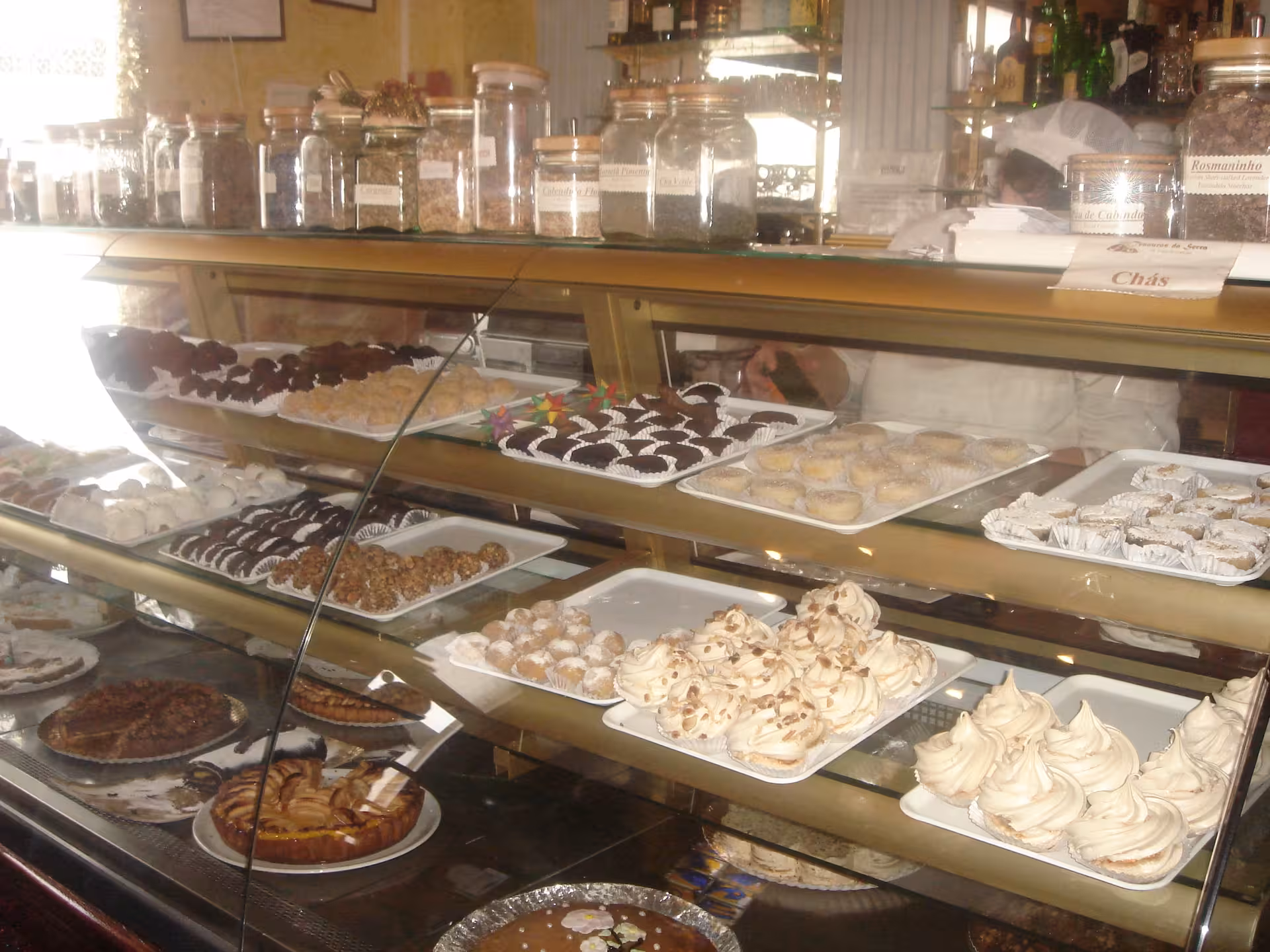 Traditional Algarve pastelaria display with homemade cakes and regional sweets on a glass counter during food tour