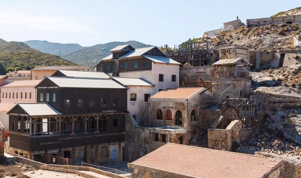 Historic mining buildings of Argentiera nestled in the Sardinian hills, showcasing the area's rich heritage on a scenic tour.
