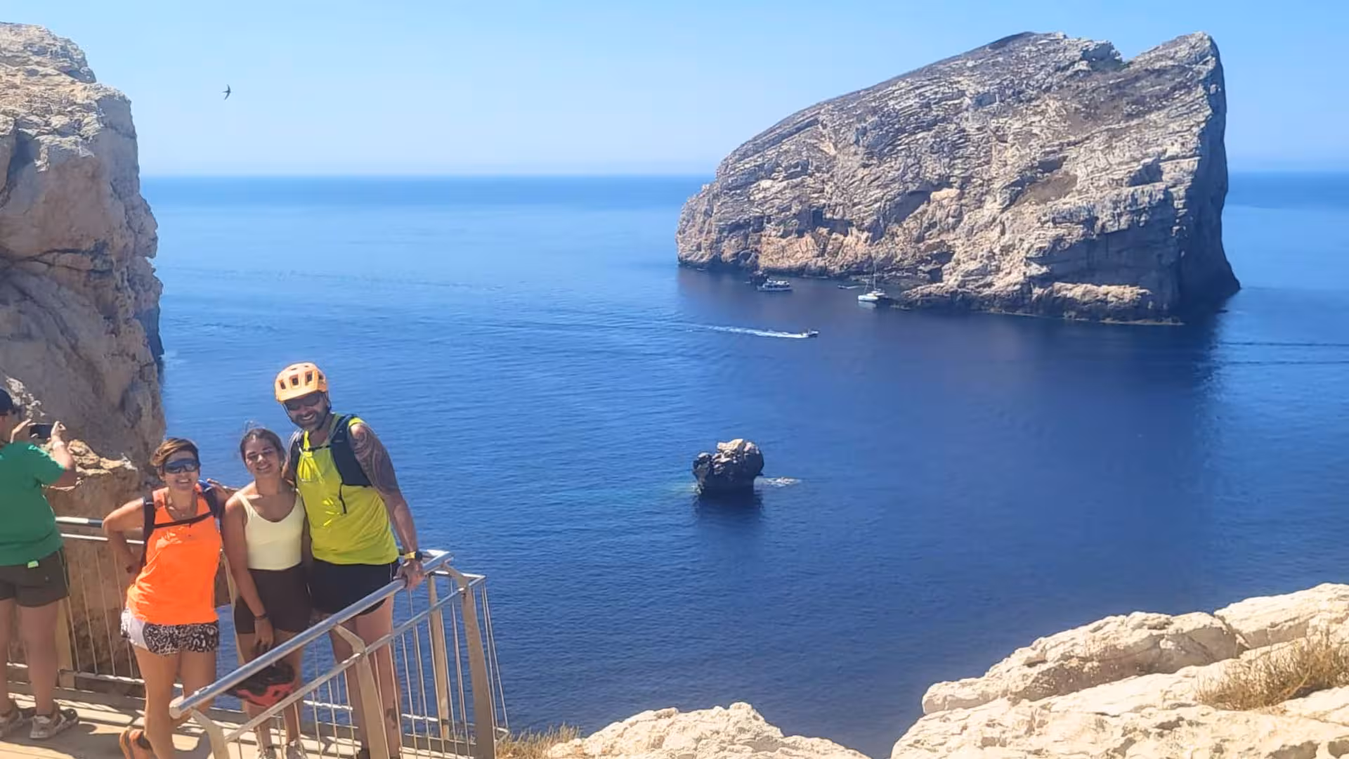 Group of cyclists enjoying the stunning sea view at Capo Caccia during an Alghero guided e-bike tour.
