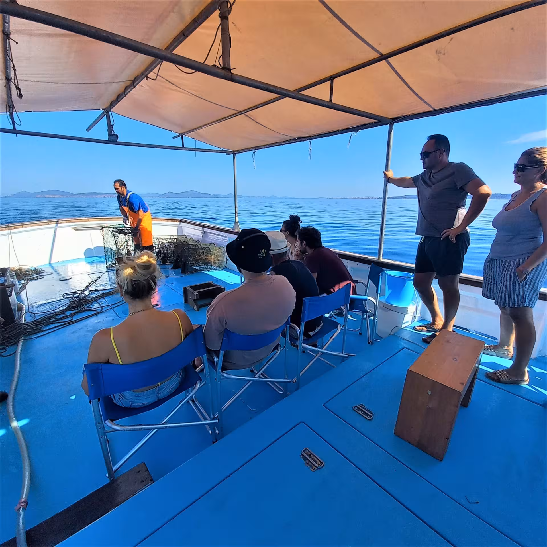 Tourists on a boat enjoy a guided fishing experience in the stunning Capo Caccia marine area near Alghero.