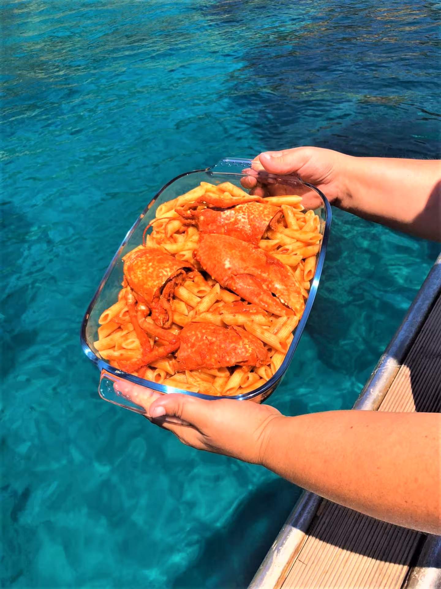 Delicious seafood pasta dish held over the sparkling waters of Capo Caccia during a fishing tour in Alghero.