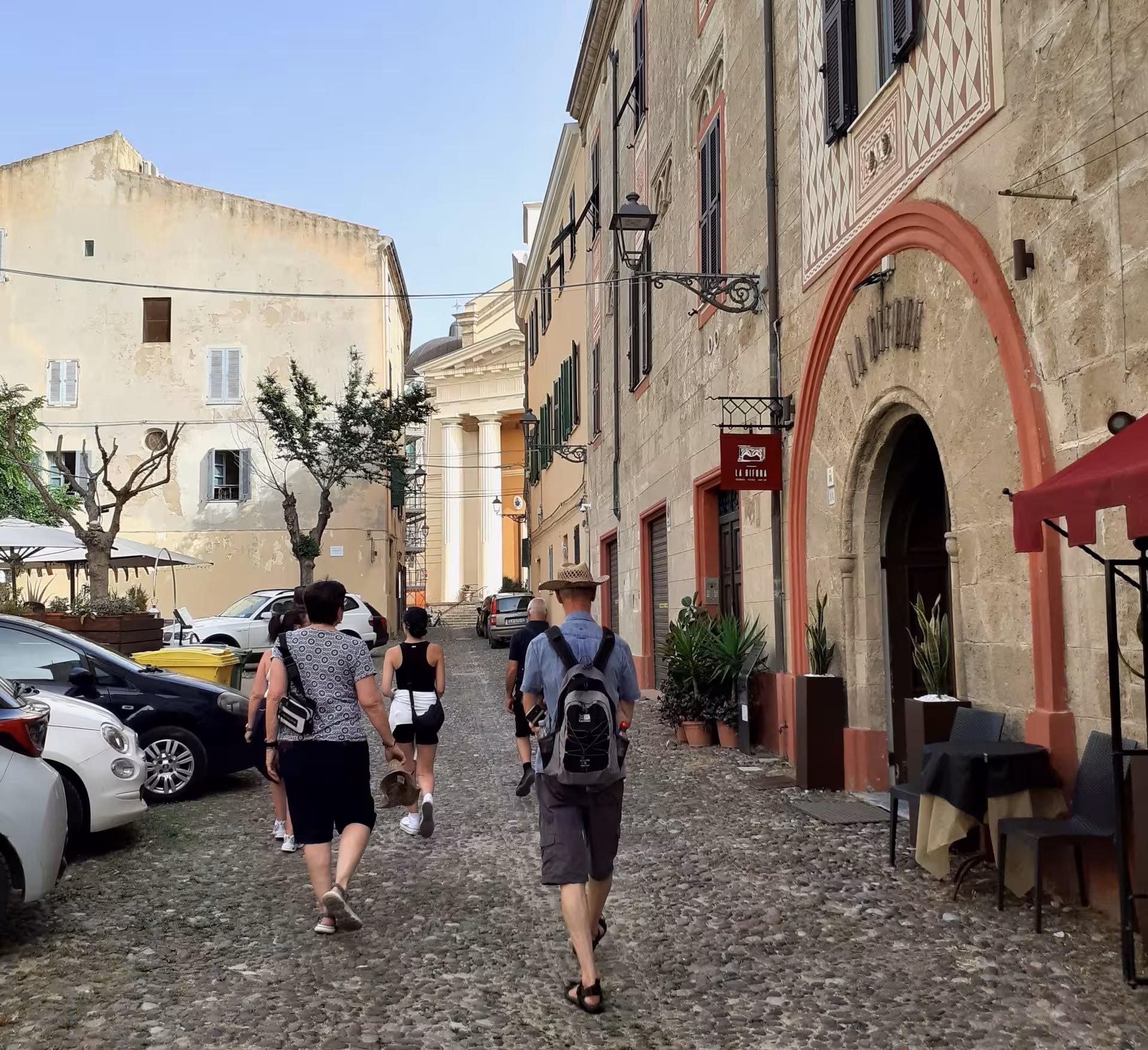 Visitors strolling through Alghero's cobblestone streets, surrounded by historic architecture and vibrant atmosphere.