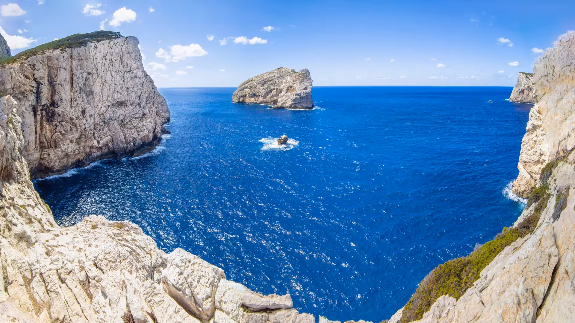 Breathtaking view of rugged cliffs and azure sea in Porto Conte Park, Alghero, ideal for scenic minivan tours.