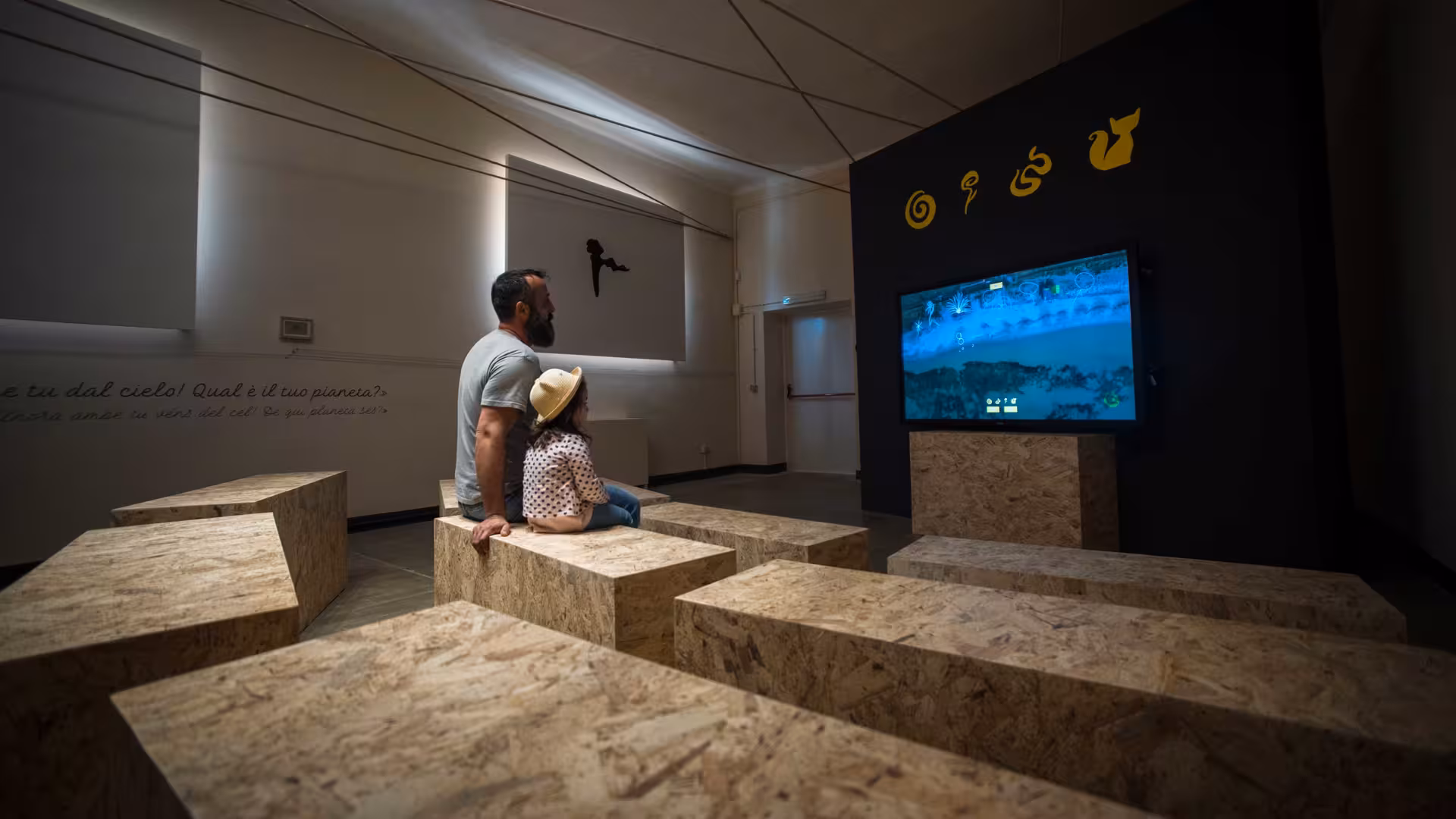 Visitors engaging with an interactive exhibit at Alghero's Porto Conte Park Ecomuseum.