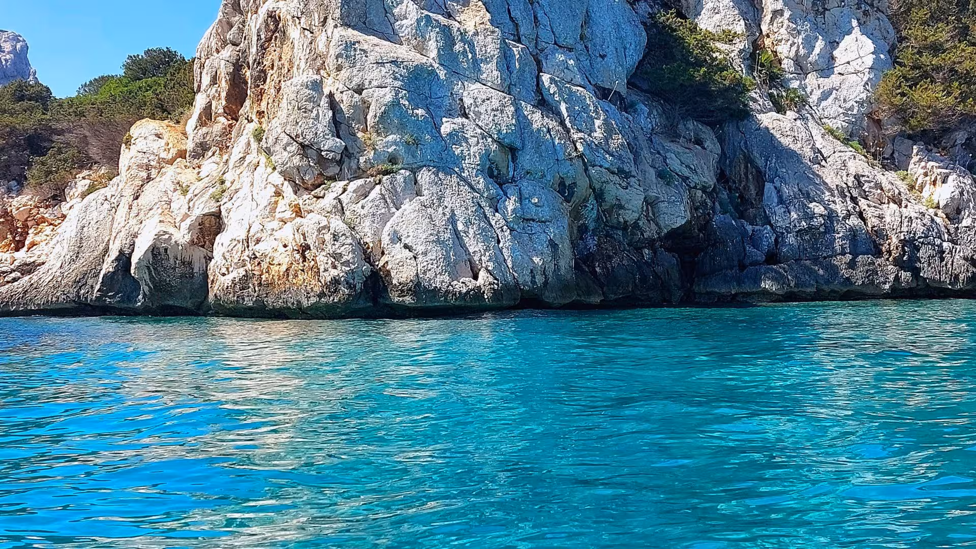 Scenic view of rugged cliffs and turquoise waters in Porto Conte Park, perfect for a nature-filled kayak tour.