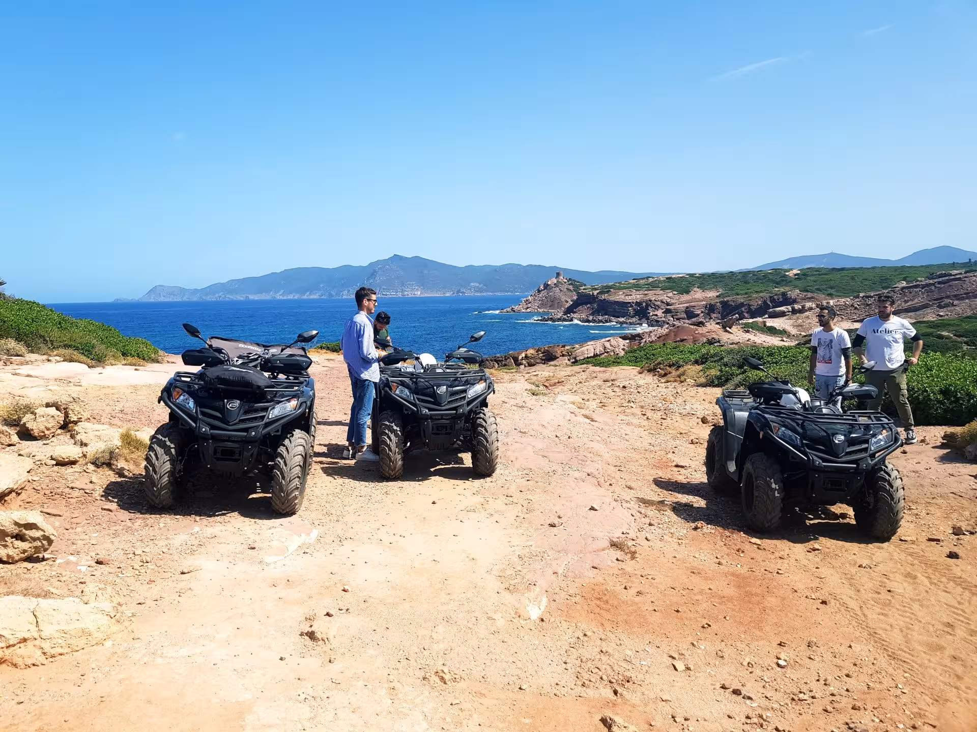 Group of people with quad bikes enjoying Alghero's breathtaking coastal views on a 4-hour off-road adventure.