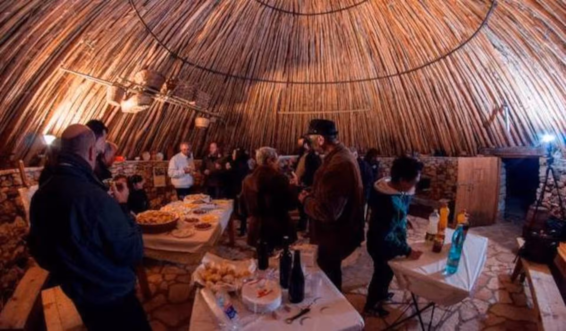 Group enjoying a saffron tasting experience in a rustic Alghero workshop with wooden interiors.