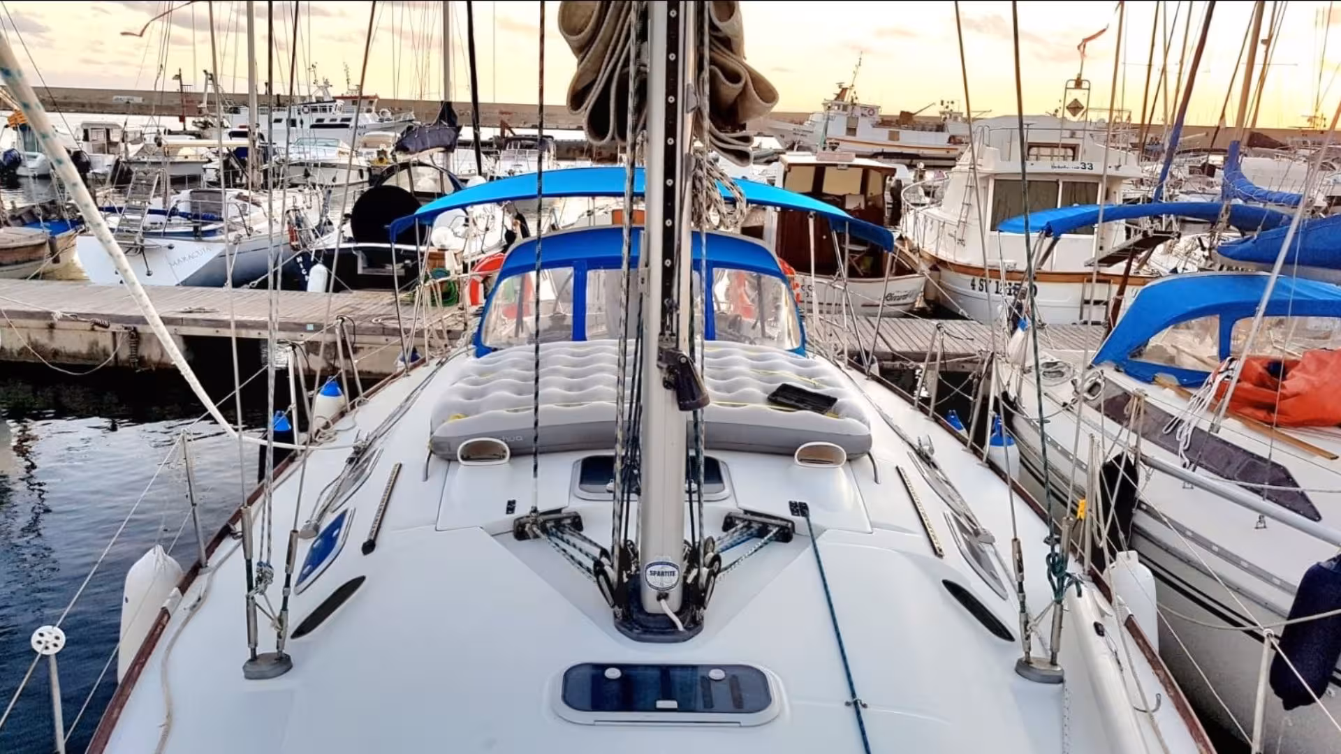 Deck of a sailboat docked in Alghero marina, showcasing a serene setting for a sailing excursion.