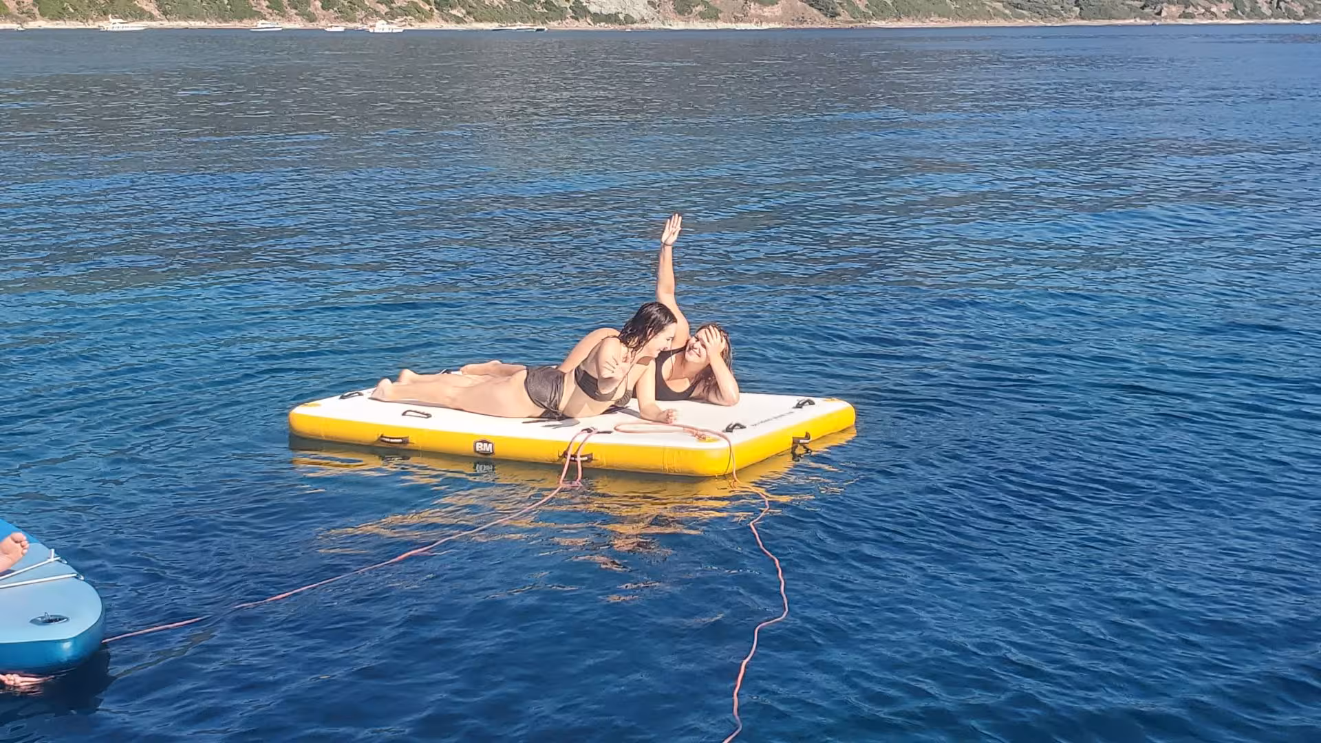 Sunbathe on a floating platform surrounded by the serene sea on an unforgettable Alghero sailboat tour.