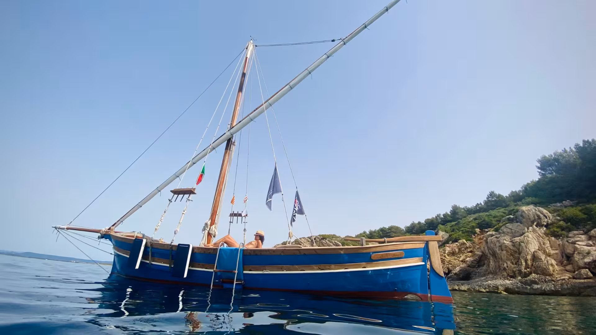 Relax on a classic sailing boat near Alghero's stunning rocky coastline during a 4-hour tour.