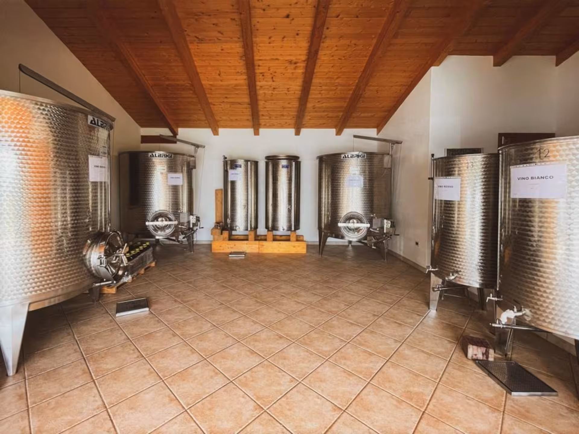 Stainless steel wine tanks in an Alghero vineyard, ready for aperitif tour visitors to explore wine production.