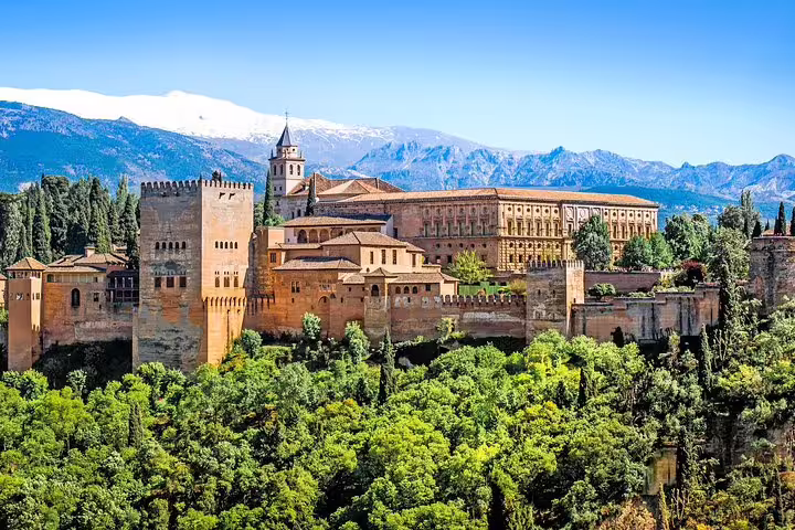 Breathtaking view of the Alhambra in Granada, surrounded by lush greenery and mountains, perfect for cruise passengers from Malaga Port.