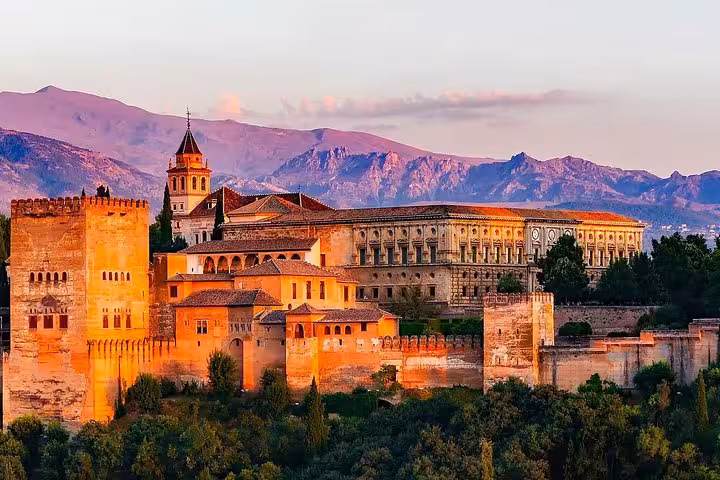 Stunning view of the Alhambra in Granada at sunset, highlighting the historic architecture and scenic backdrop for tours.
