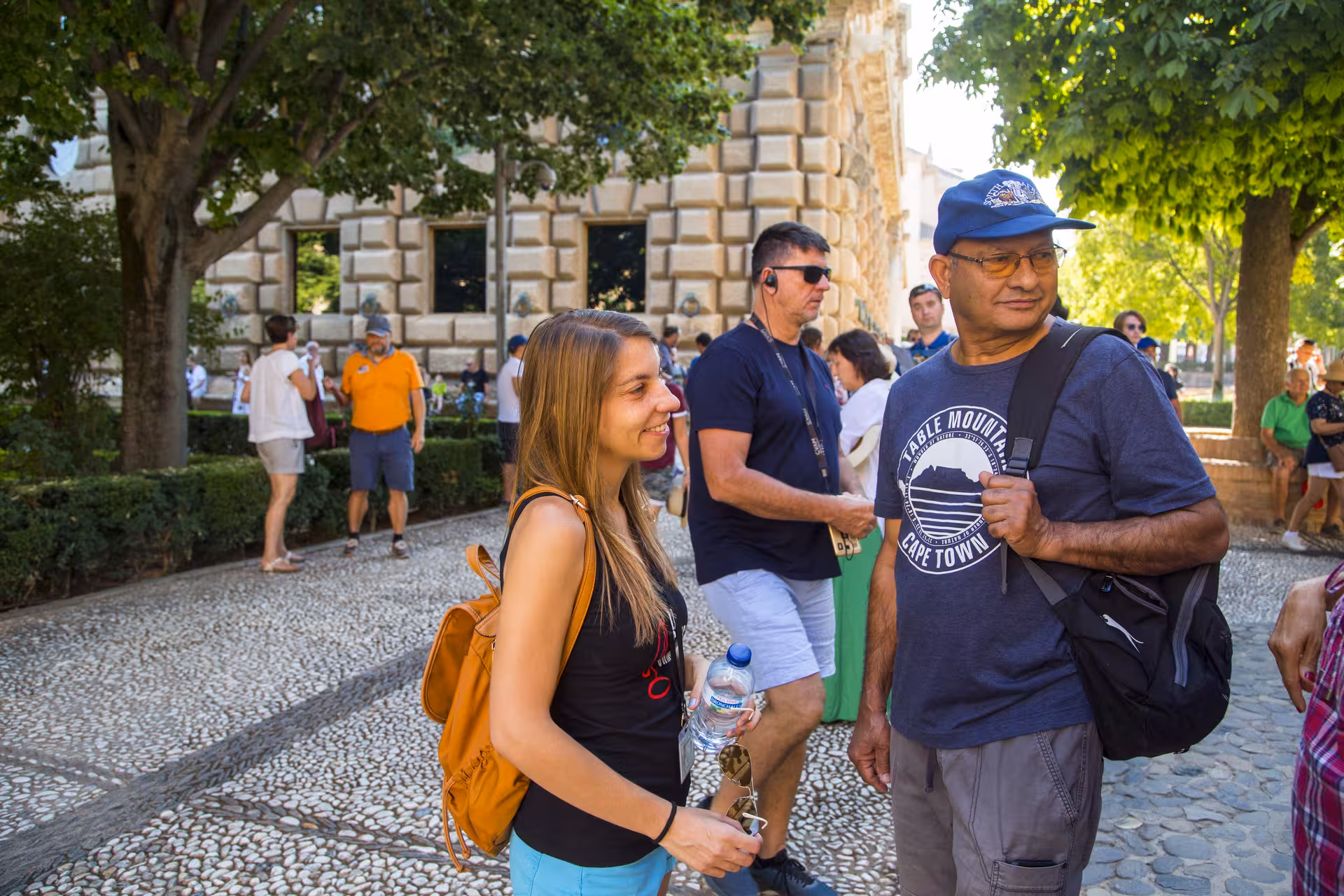Visitors enjoying a guided tour at the Alhambra, surrounded by lush gardens and historic architecture, enhancing the cultural experience.