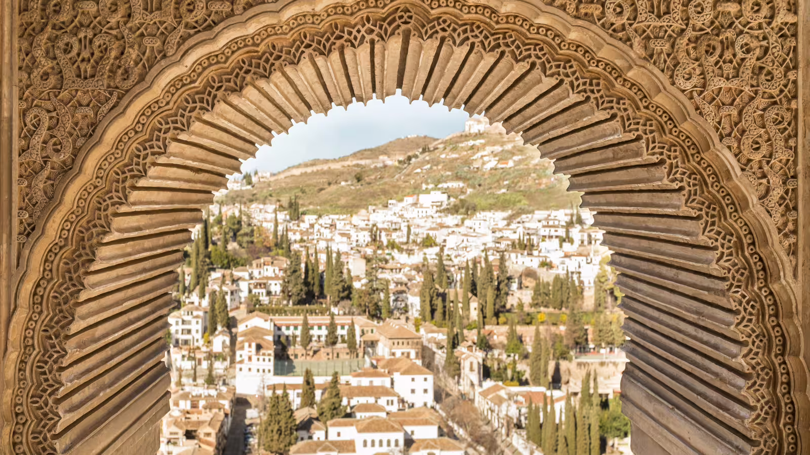 Moorish arch window framing Granada’s Albaicín views, Alhambra private tour from Costa del Sol with guide