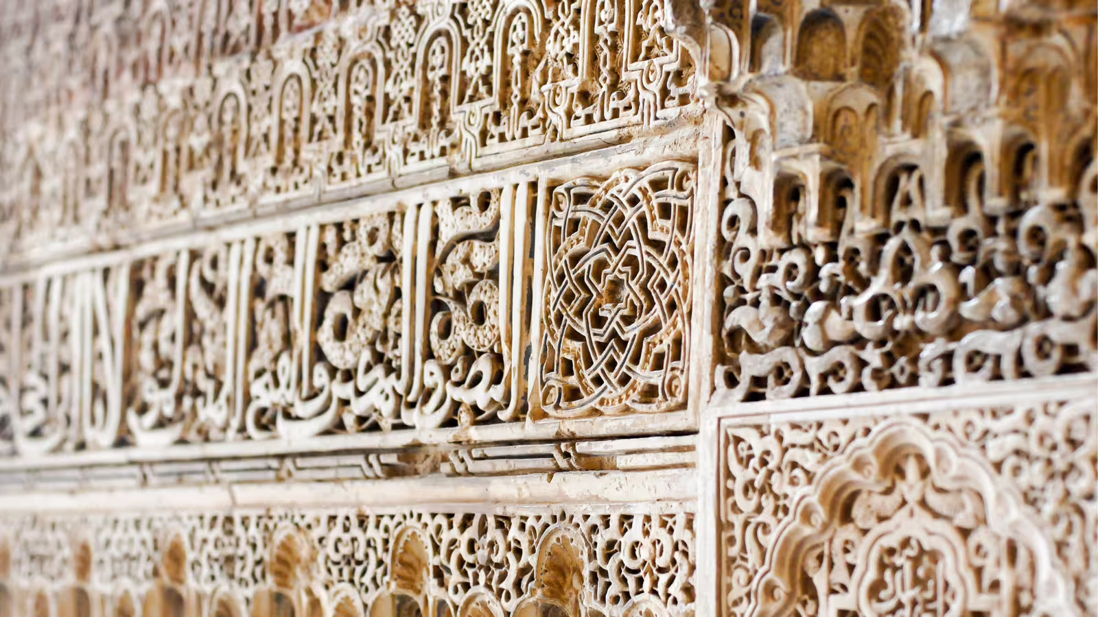 Close-up of Alhambra Nasrid Palace stucco carvings and Arabic calligraphy on a private tour from Costa del Sol