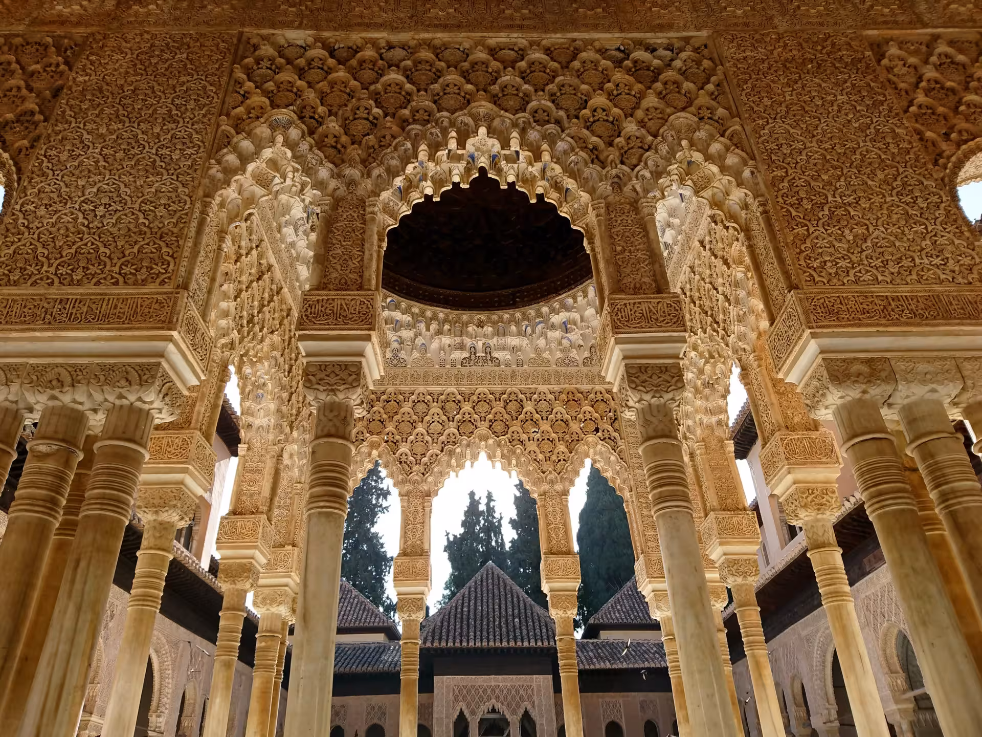 Stunning arches and detailed carvings in the Alhambra's Court of the Lions, exemplifying Nasrid artistry.