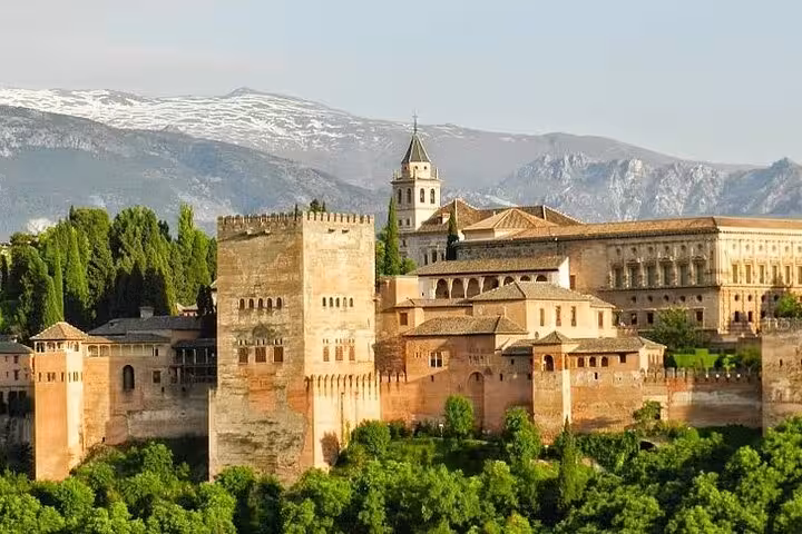 Panoramic view of the Alhambra Palace in Granada with Sierra Nevada mountains, a key site on the Andalucia and Madrid tour.