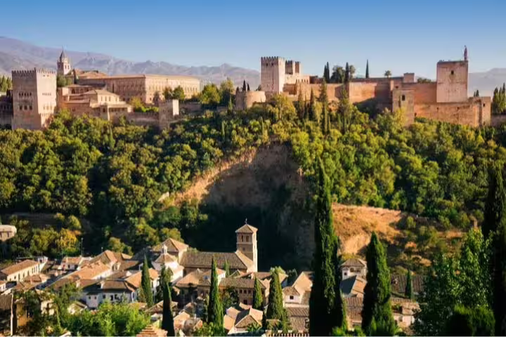 Scenic view of Alhambra Palace in Granada surrounded by lush greenery, ideal for cruise passengers touring from Malaga Port.