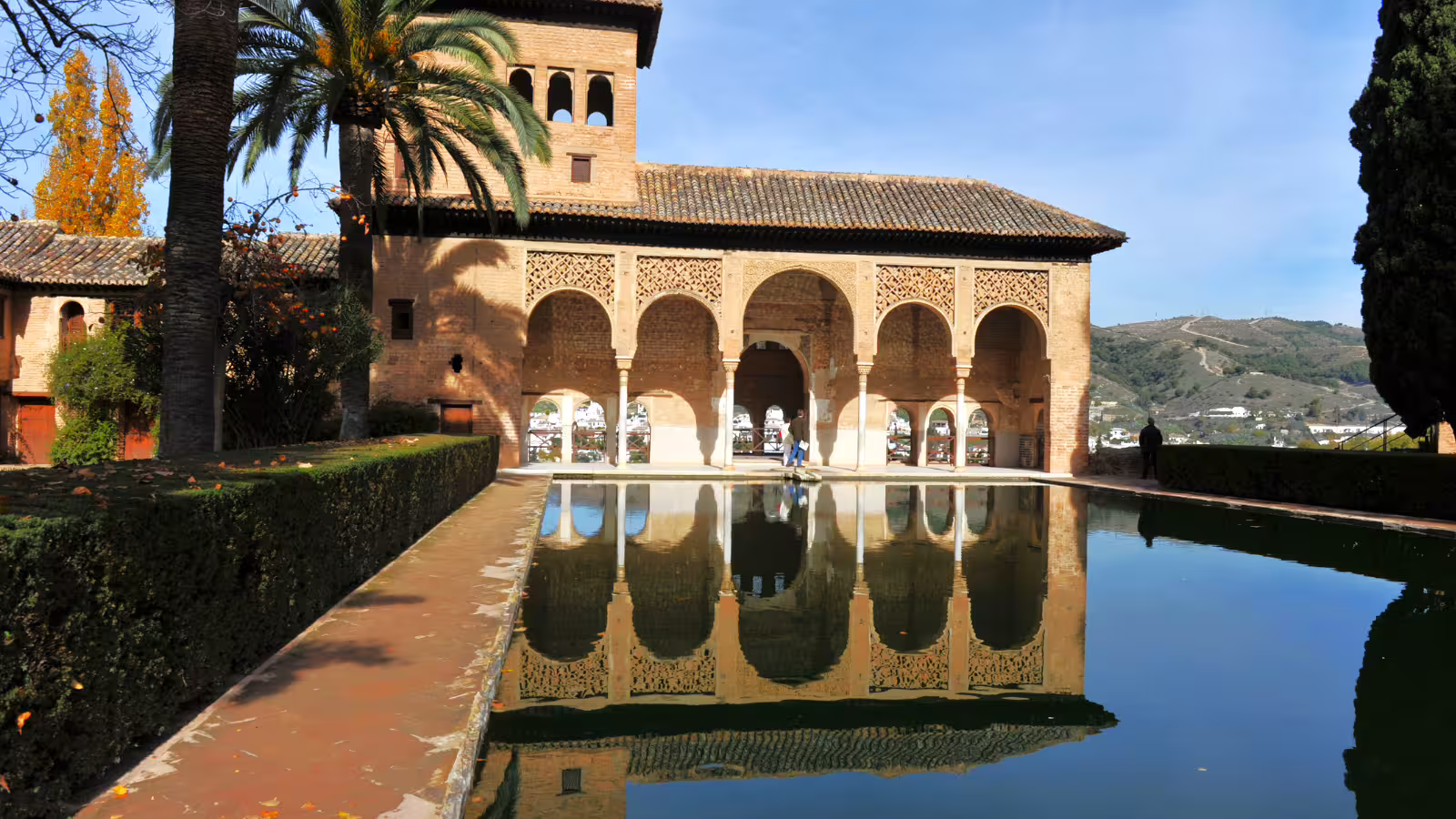 Alhambra Palace reflecting pool in Granada, serene Moorish arches on a private guided tour with hotel pick-up
