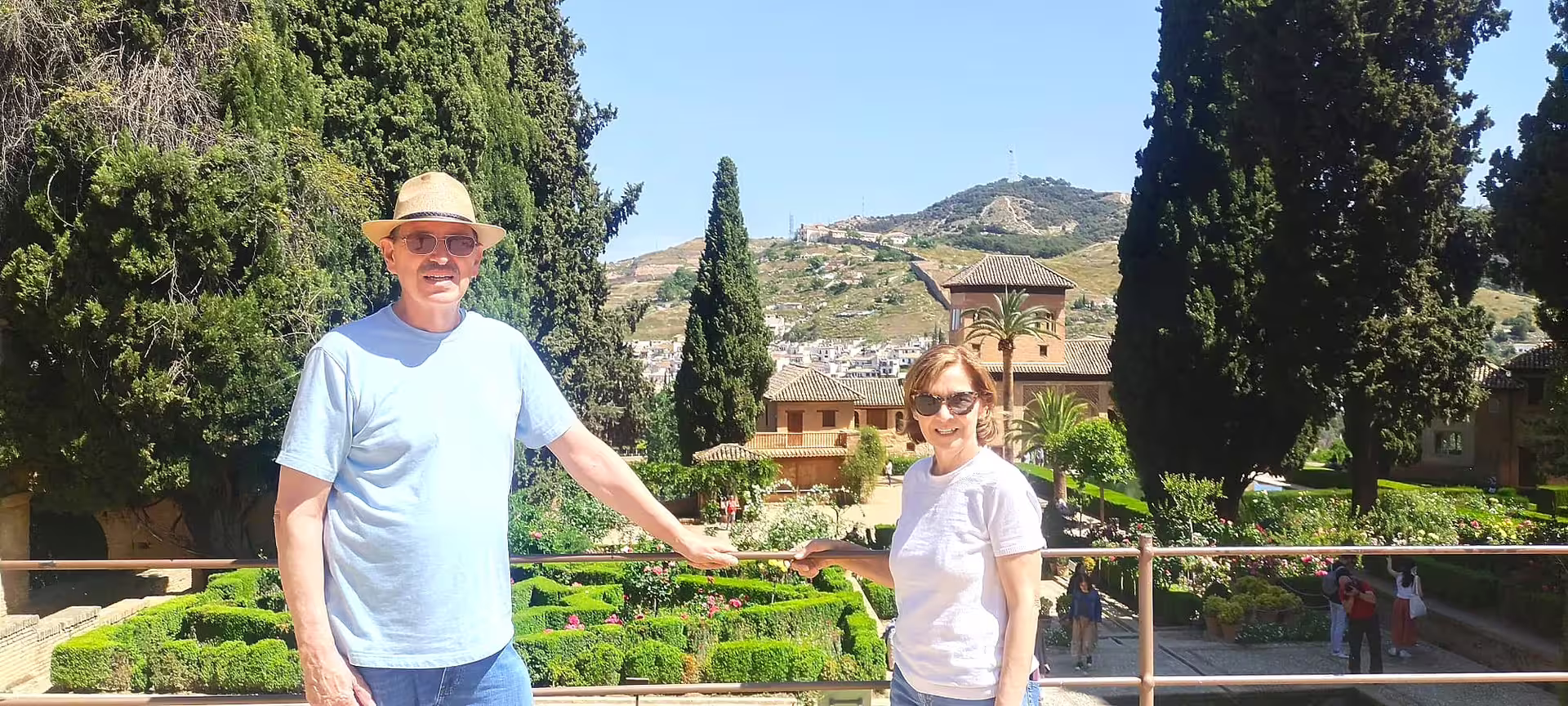 Guests on an Alhambra private walking tour overlooking Generalife gardens and Granada hills on a sunny day