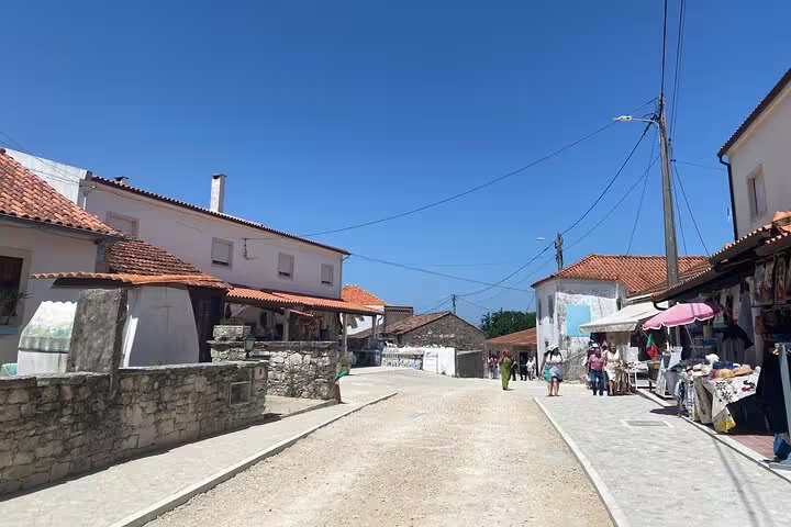 Quaint street scene in Aljustrel village, showcasing local shops and architecture, on the Fátima tour from Lisbon.